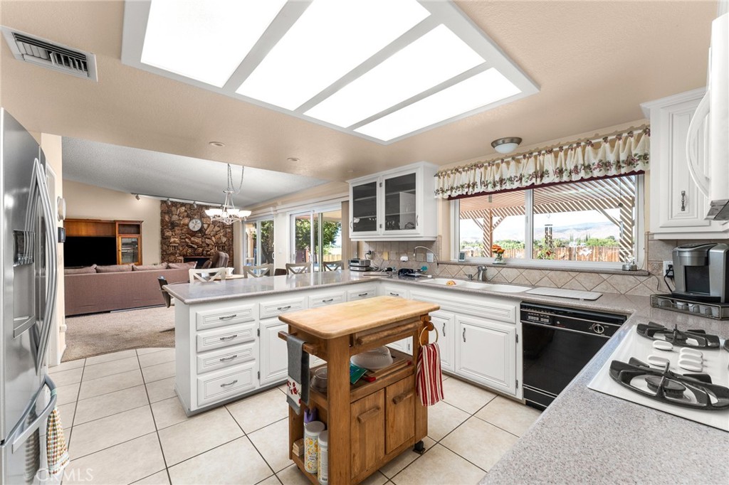 13346 Rimview Court Yucaipa, CA 92399 - Photo 21 of 60 a kitchen with stainless steel appliances a stove sink and cabinets