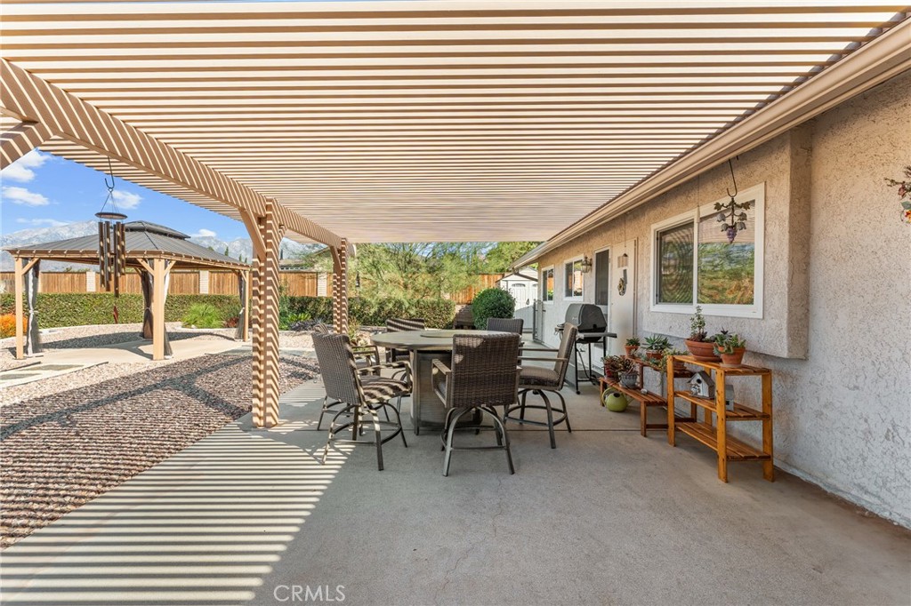 13346 Rimview Court Yucaipa, CA 92399 - Photo 42 of 60 a view of a patio with table and chairs with wooden floor and fence