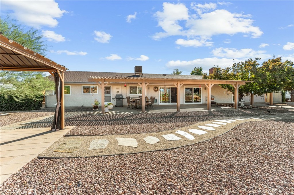 13346 Rimview Court Yucaipa, CA 92399 - Photo 45 of 60 a view of a white house next to a yard with big trees