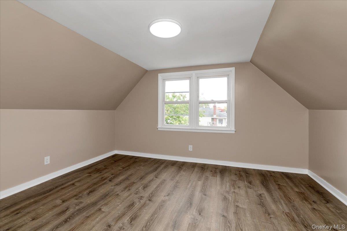 301 Merrifield Avenue Oceanside, NY 11572 - Photo 12 of 16 an empty room with wooden floor and windows