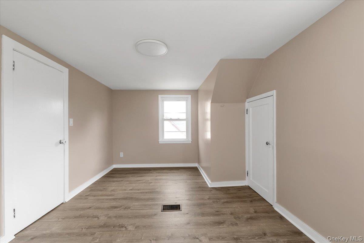 301 Merrifield Avenue Oceanside, NY 11572 - Photo 15 of 16 a view of an empty room with wooden floor and a window