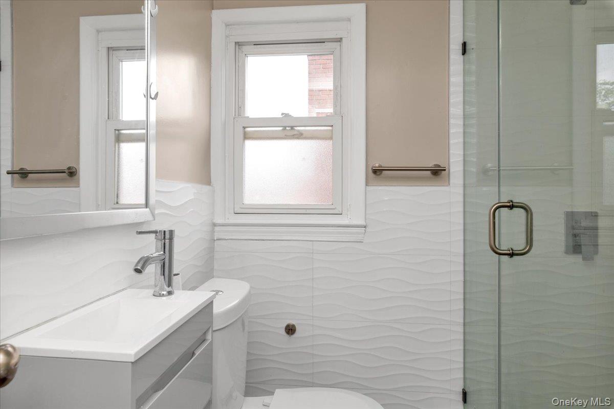 301 Merrifield Avenue Oceanside, NY 11572 - Photo 16 of 16 a bathroom with a sink a toilet and shower
