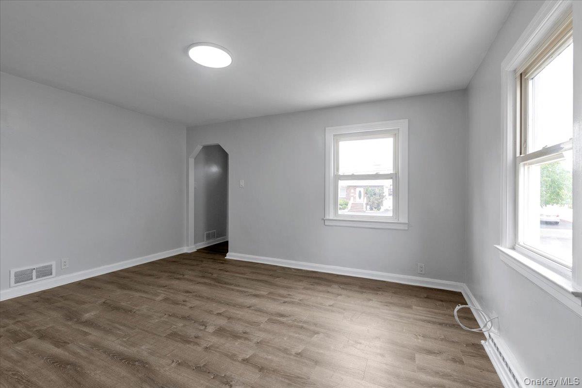 301 Merrifield Avenue Oceanside, NY 11572 - Photo 5 of 16 an empty room with wooden floor and windows