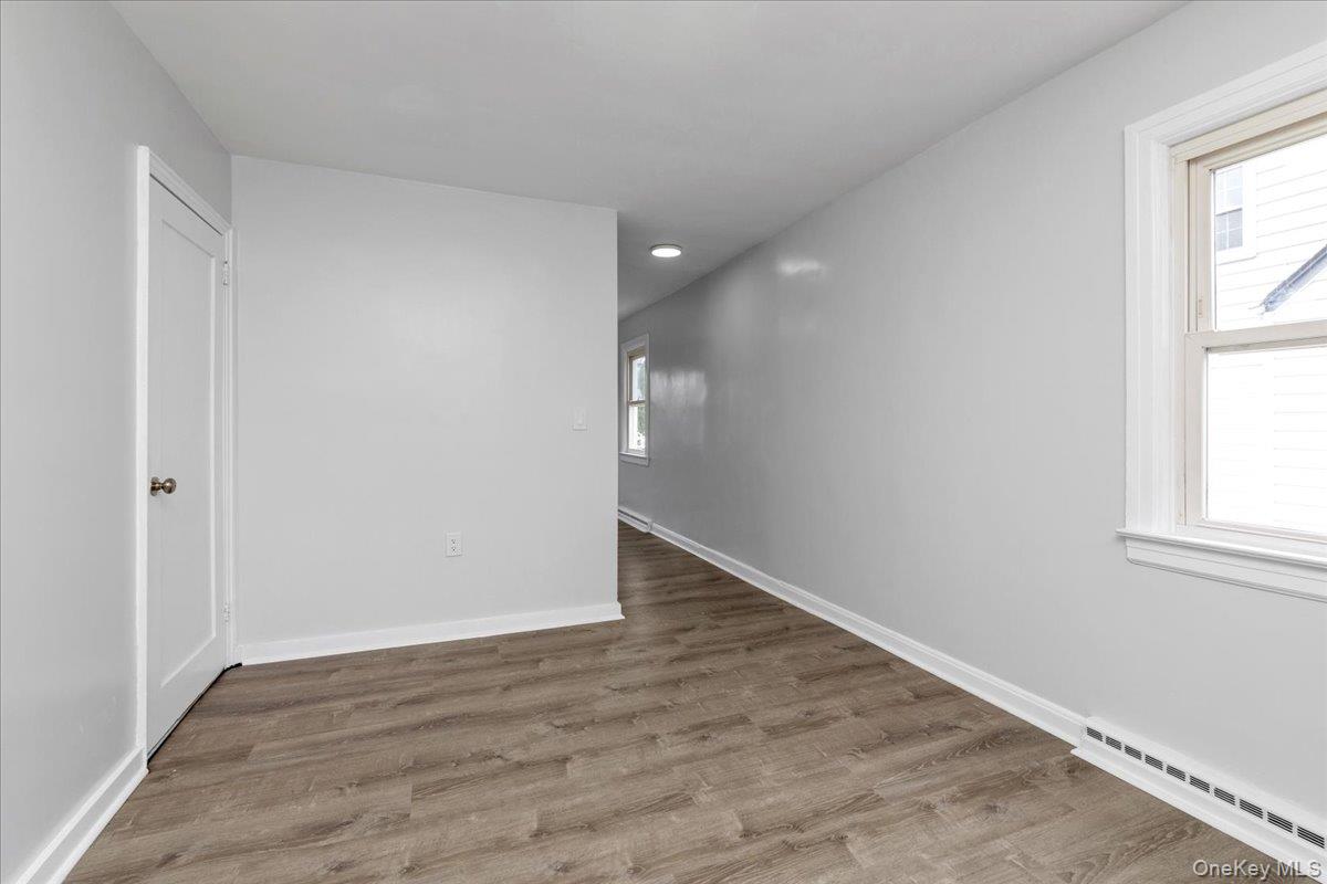 301 Merrifield Avenue Oceanside, NY 11572 - Photo 8 of 16 an empty room with wooden floor and windows