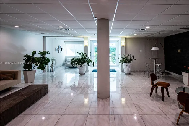 a lobby with furniture and potted plants