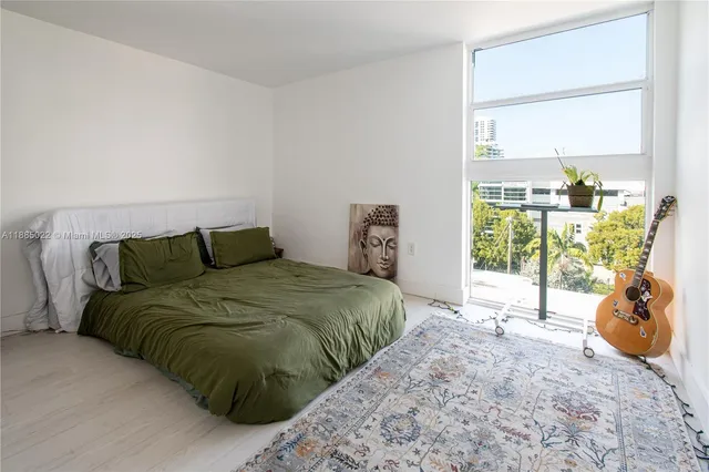 a bed sitting in a bedroom next to a window