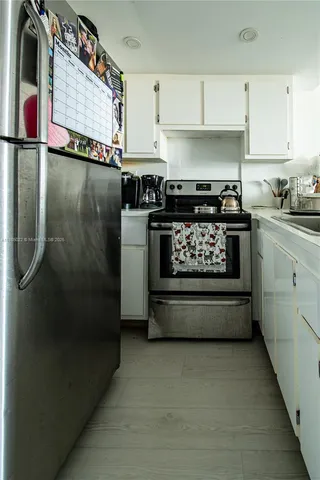 a kitchen with stainless steel appliances granite countertop a refrigerator a stove a sink and dishwasher