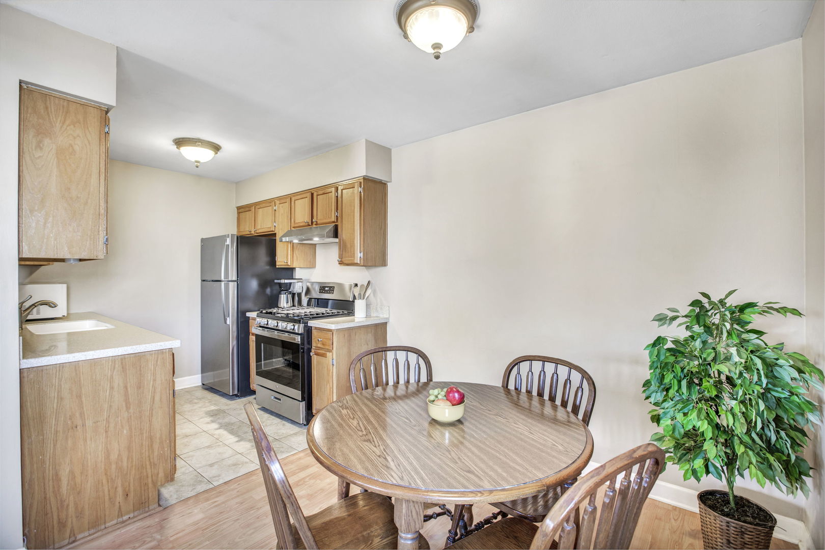 817 Pahl Road Elk Grove Village, IL 60007 - Photo 6 of 17 a kitchen with granite countertop a table chairs stove and refrigerator