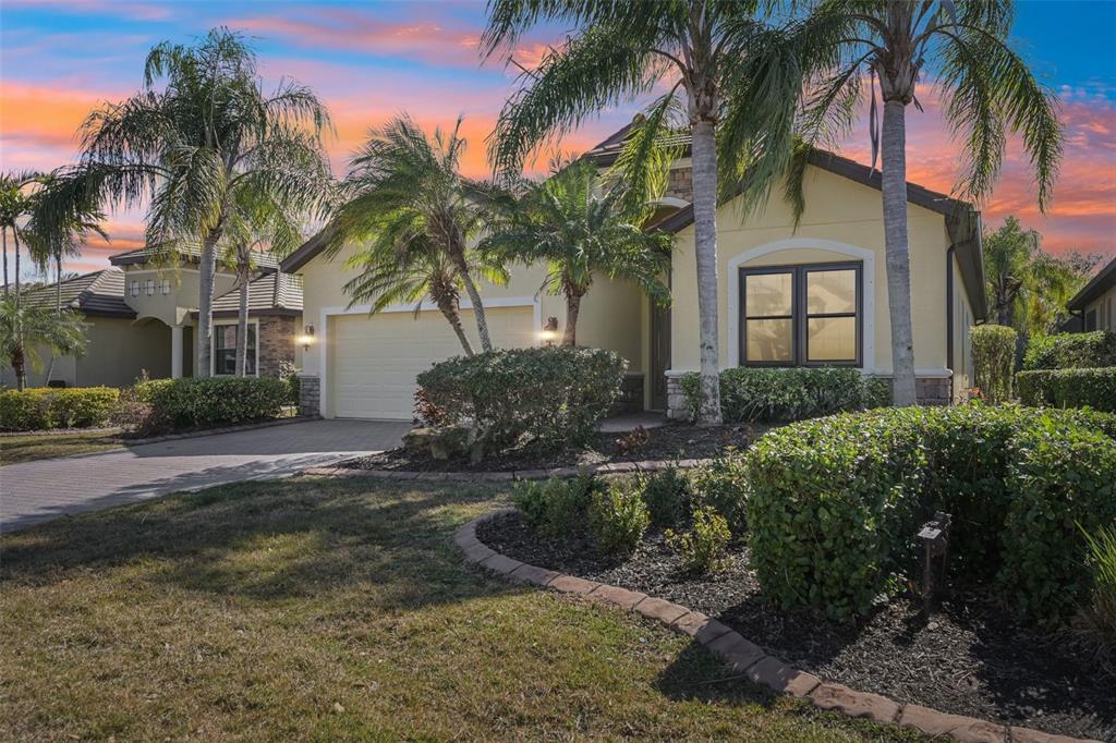 a view of a house with a yard and palm trees