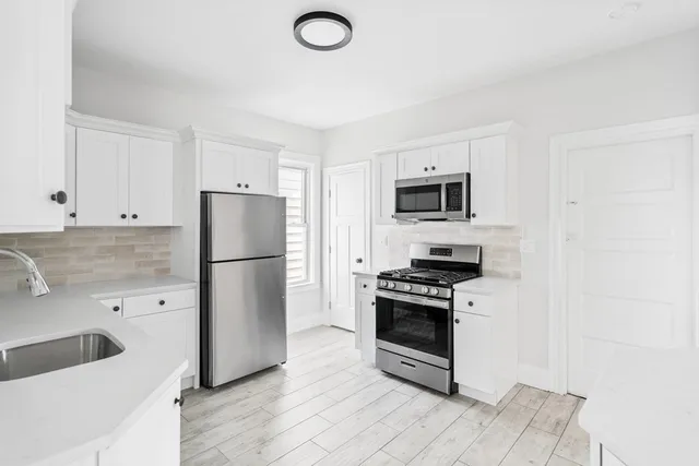 a kitchen with a refrigerator sink and stove top oven
