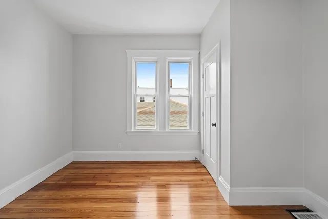 a view of a room with wooden floor and windows