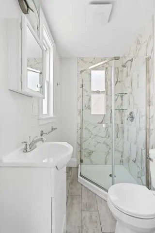 a bathroom with a sink a toilet and shower