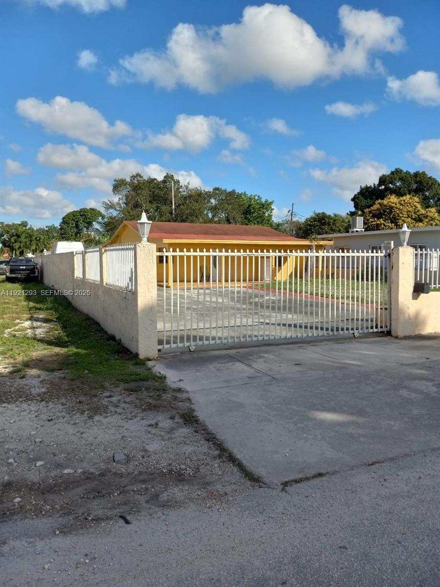 3041 Northwest 95th Terrace Miami, FL 33147 - Photo 20 of 22 a view of a pathway with a wrought fence