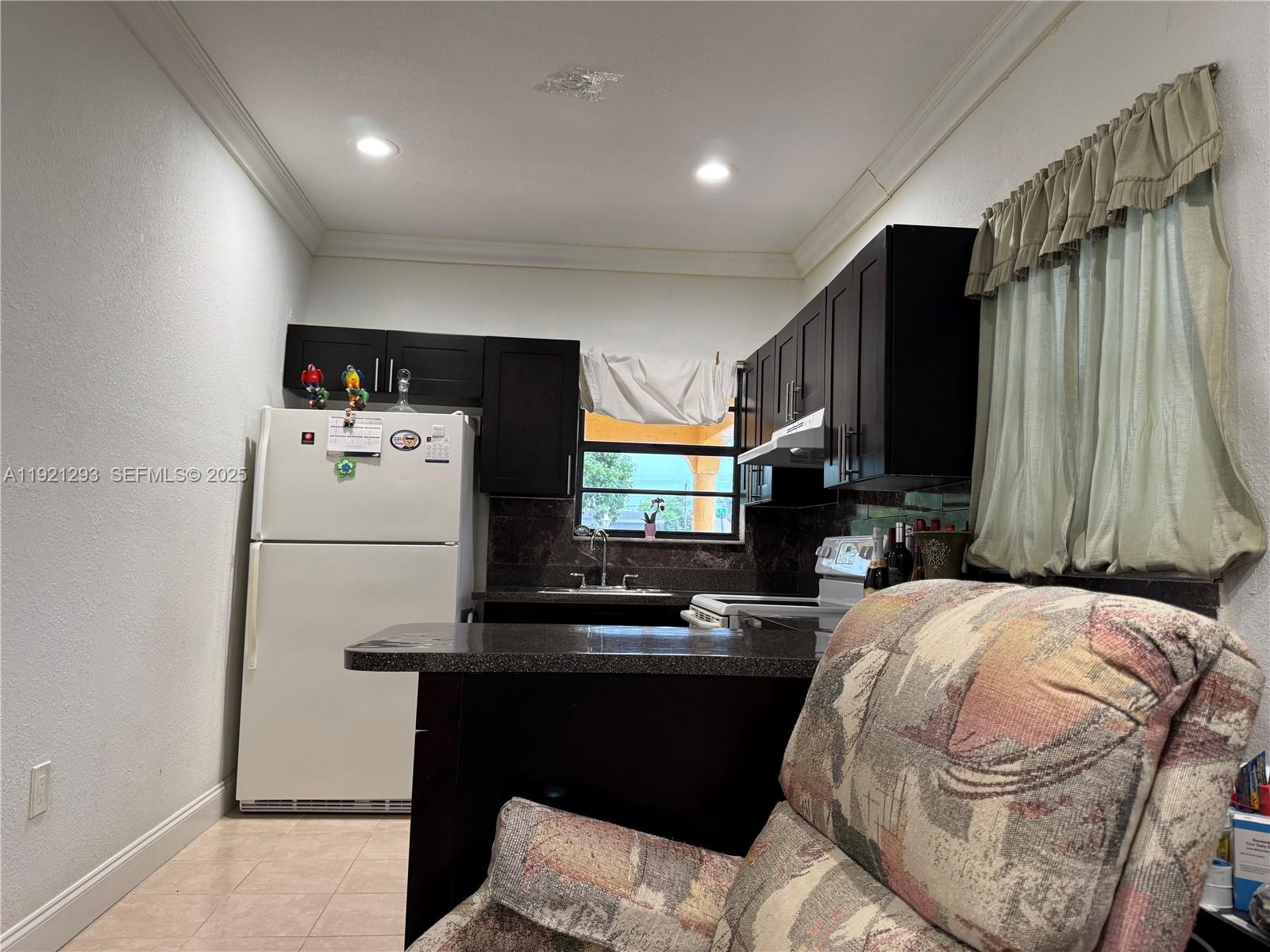 3041 Northwest 95th Terrace Miami, FL 33147 - Photo 5 of 22 a kitchen with a refrigerator and a stove