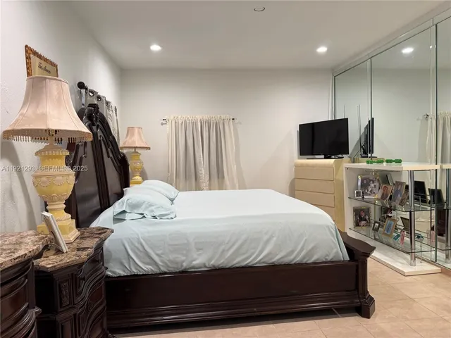 a bedroom with a bed and a flat screen tv