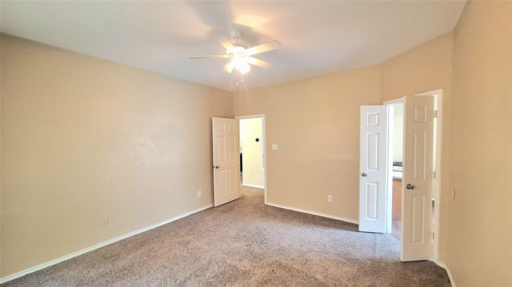 953 Hannah Way Dallas, TX 75253 - Photo 18 of 22 Spacious room featuring neutral carpeting, light beige wall finishes, and a ceiling fan with integrated lighting