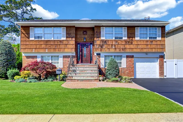 a view of a house with a yard potted plants and a wooden bench