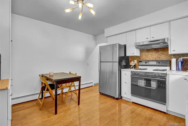 a kitchen with stainless steel appliances a stove a refrigerator and a fireplace