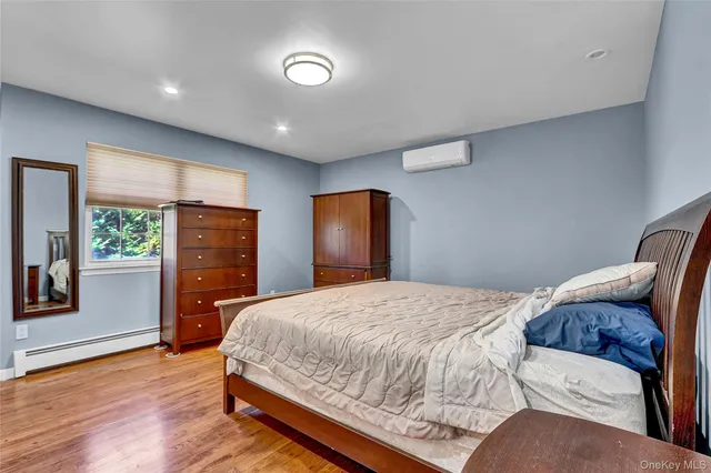 a bedroom with a large bed and wooden floor