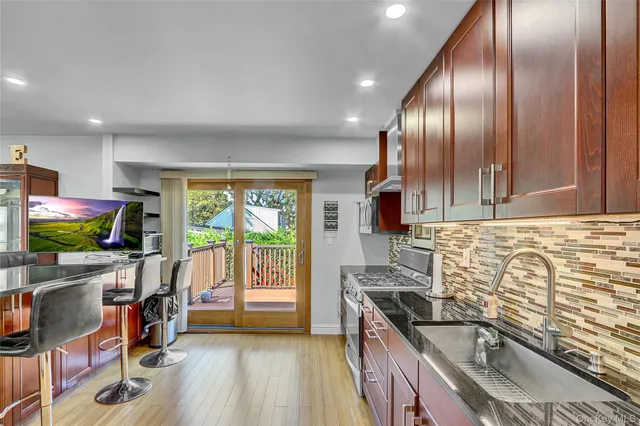 a kitchen with stainless steel appliances granite countertop a sink stove and cabinets