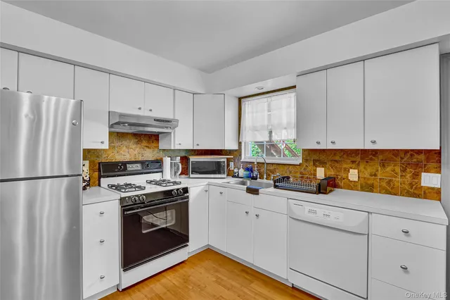 a kitchen with white cabinets sink and white appliances
