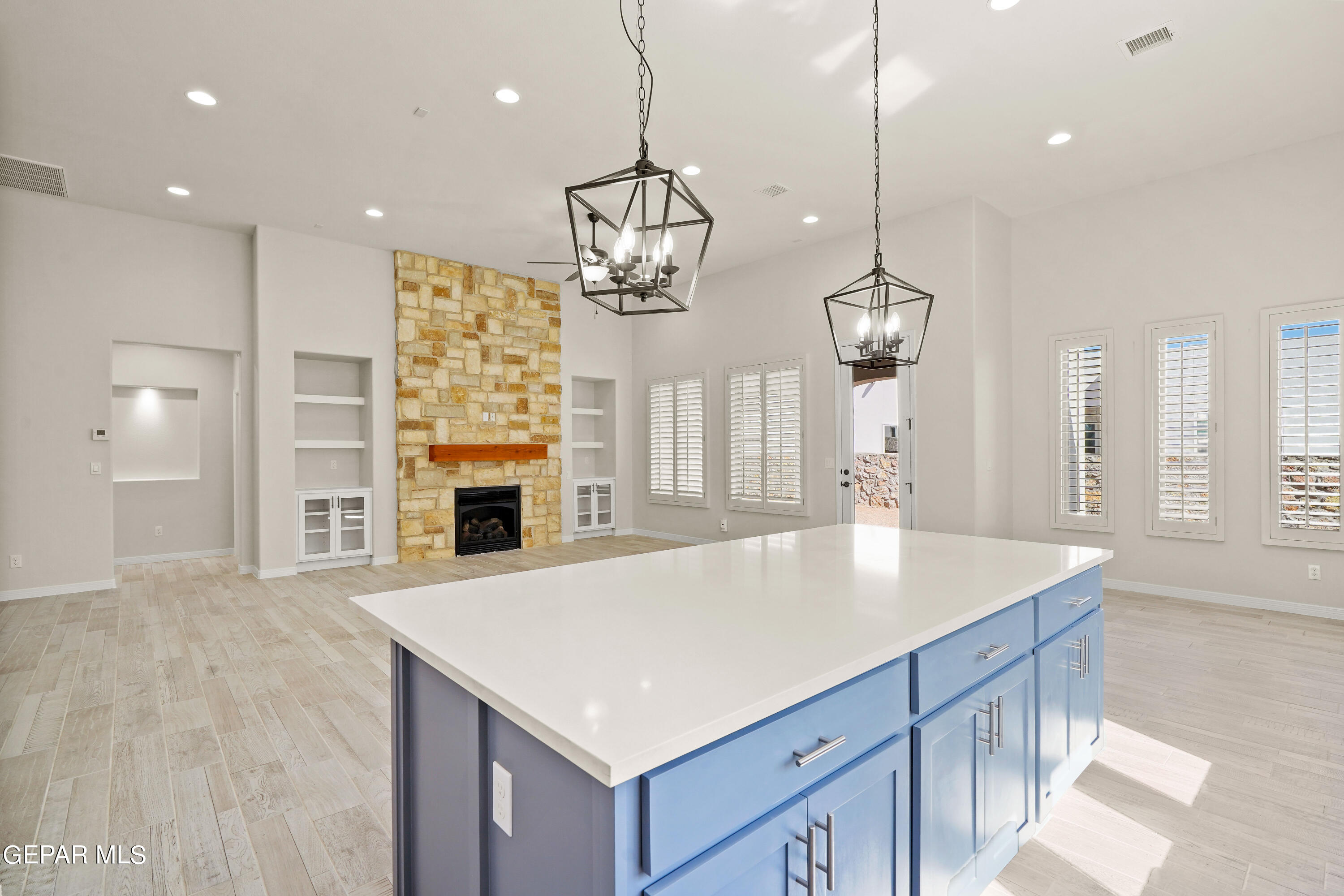 1734 Bit Way El Paso, TX 79911 - Photo 14 of 52 a kitchen with a center island wooden floor and a chandelier