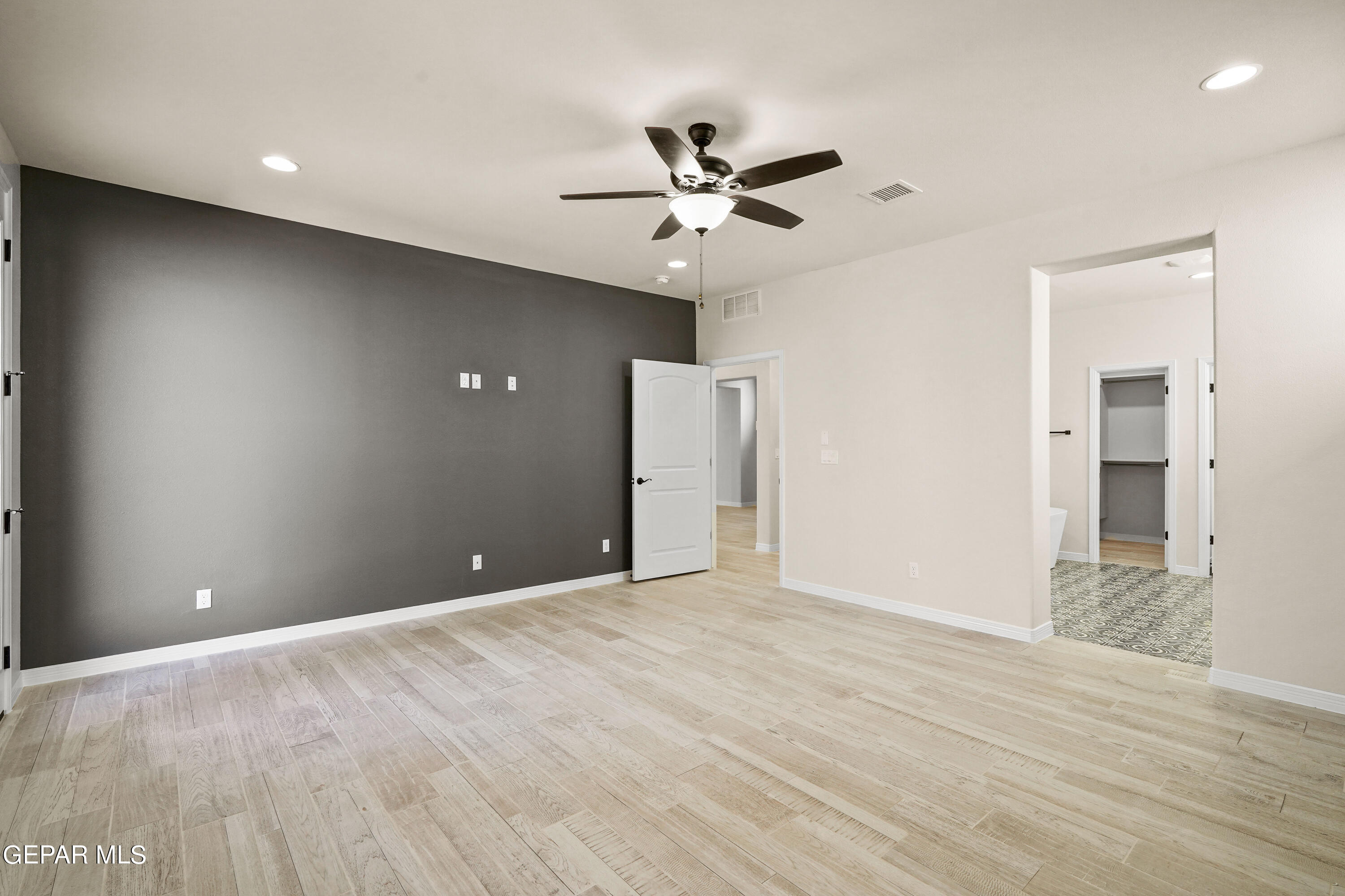 1734 Bit Way El Paso, TX 79911 - Photo 22 of 52 a view of an empty room with wooden floor and a ceiling fan