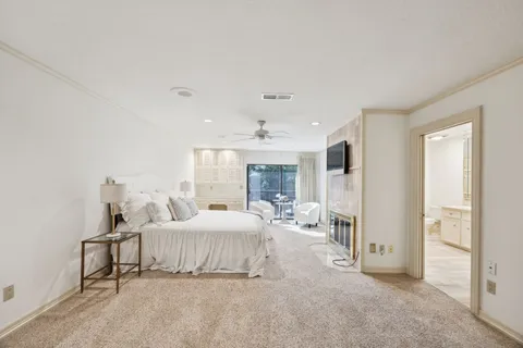 a bedroom with a bed large window and a chandelier