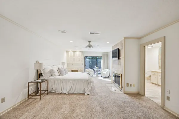 a bedroom with a bed large window and a chandelier