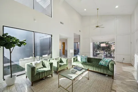 a living room with furniture potted plant and a large window