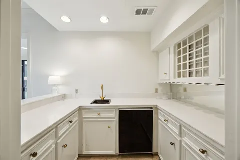 a kitchen with granite countertop white cabinets and white appliances