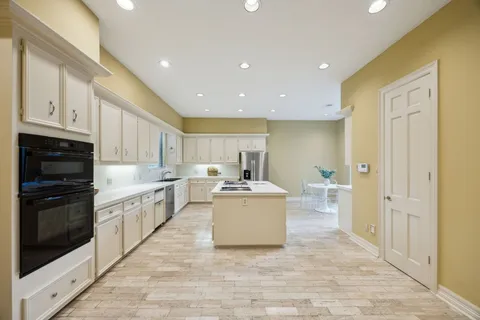a large white kitchen with stainless steel appliances