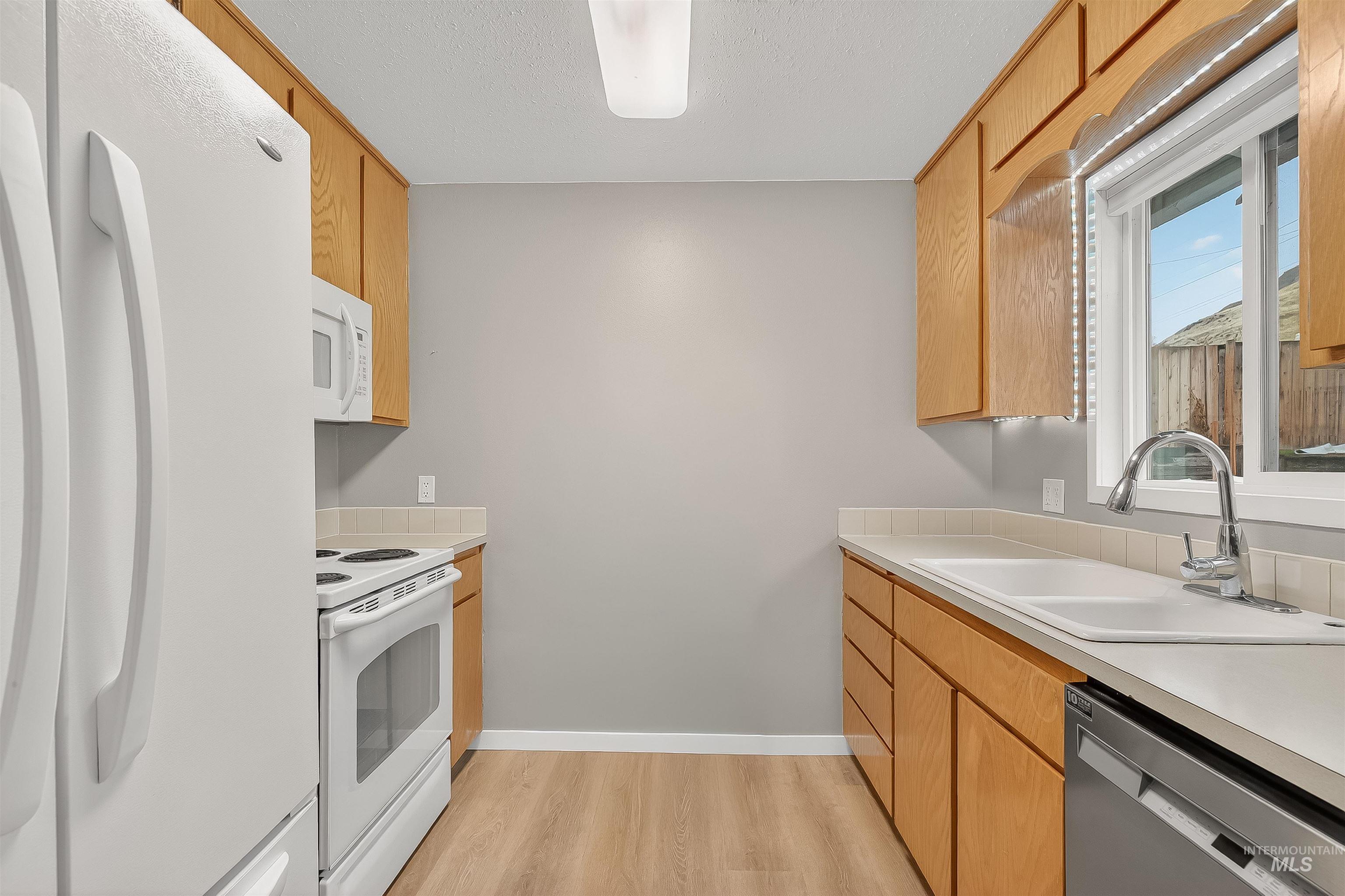 406 2nd Street Asotin, WA 99402 - Photo 11 of 37 Kitchen with white appliances, light countertops, and light wood-style floors