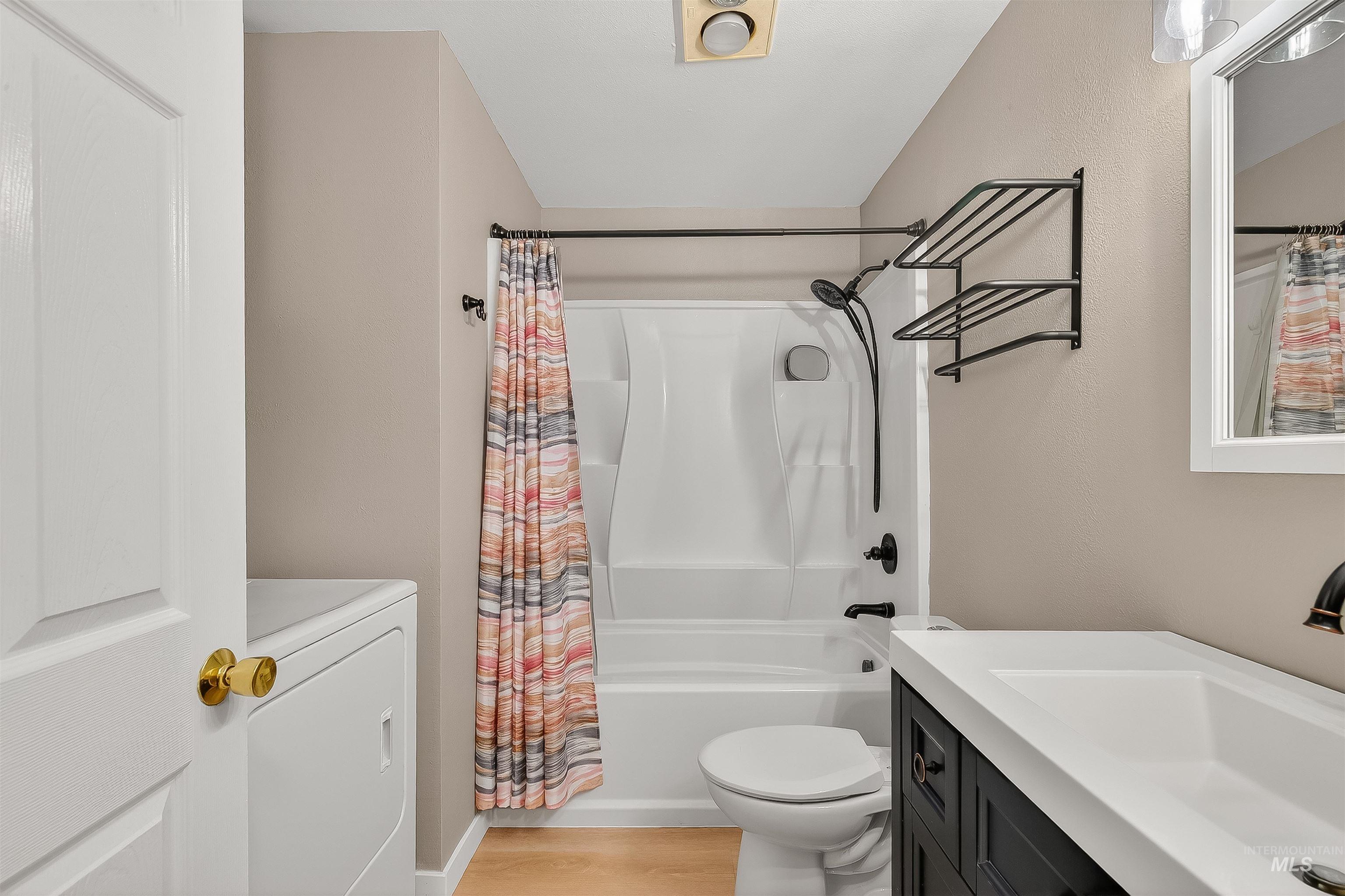 406 2nd Street Asotin, WA 99402 - Photo 13 of 37 Bathroom with shower / tub combo with curtain, washer / clothes dryer, vanity, and light wood-style flooring