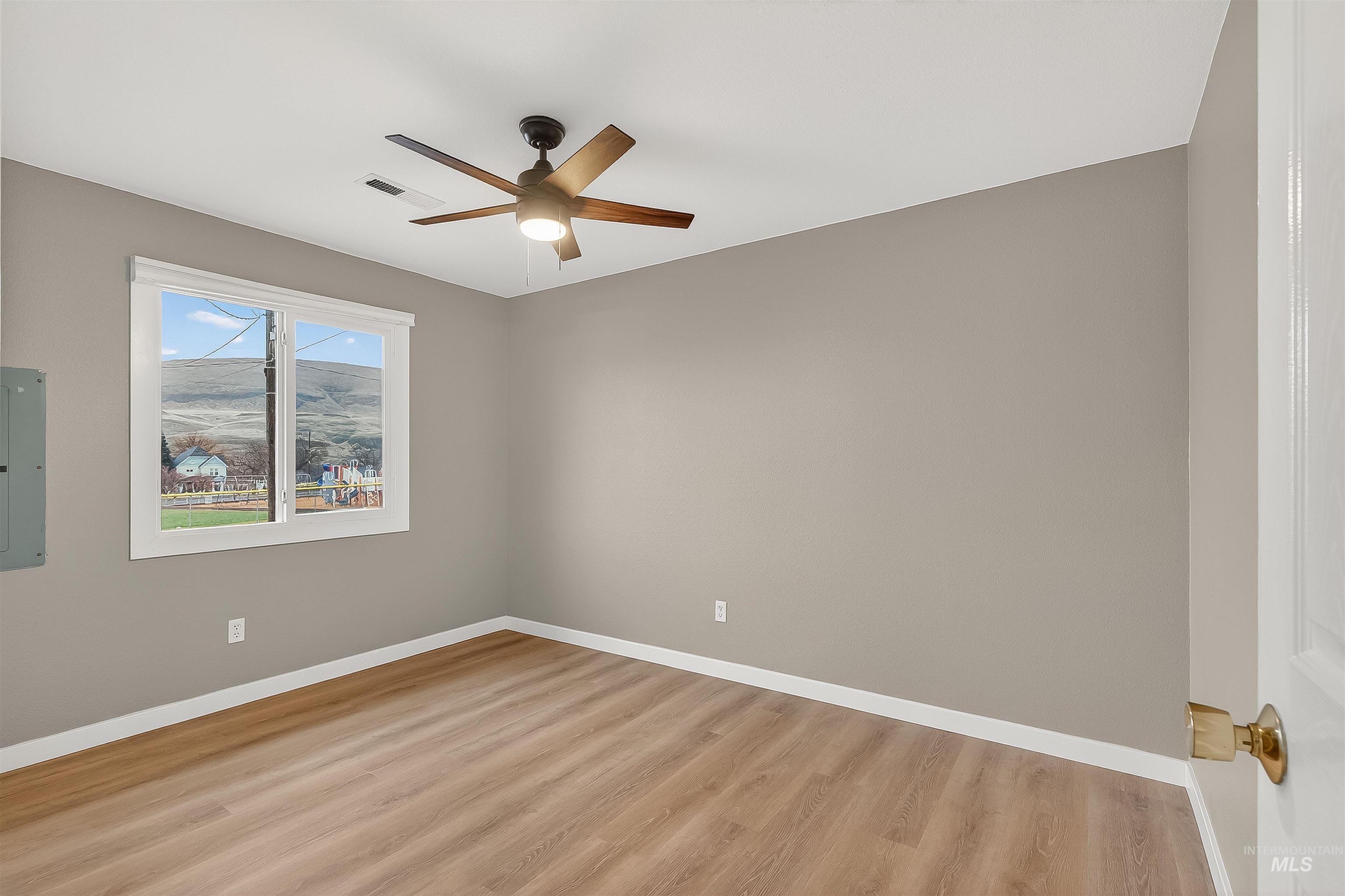 406 2nd Street Asotin, WA 99402 - Photo 17 of 37 Unfurnished room featuring light wood-style floors, electric panel, and a ceiling fan