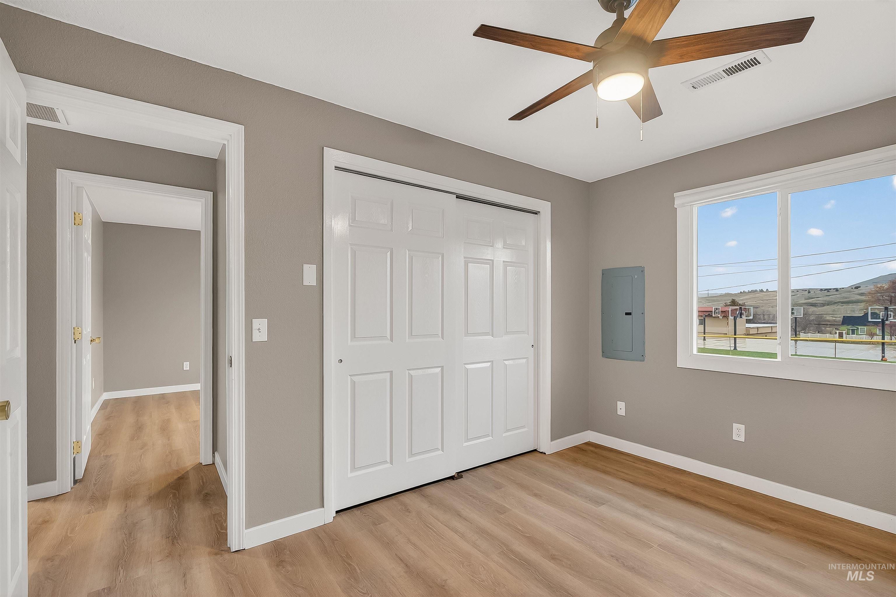 406 2nd Street Asotin, WA 99402 - Photo 18 of 37 Unfurnished bedroom with light wood-type flooring, a closet, electric panel, and a ceiling fan