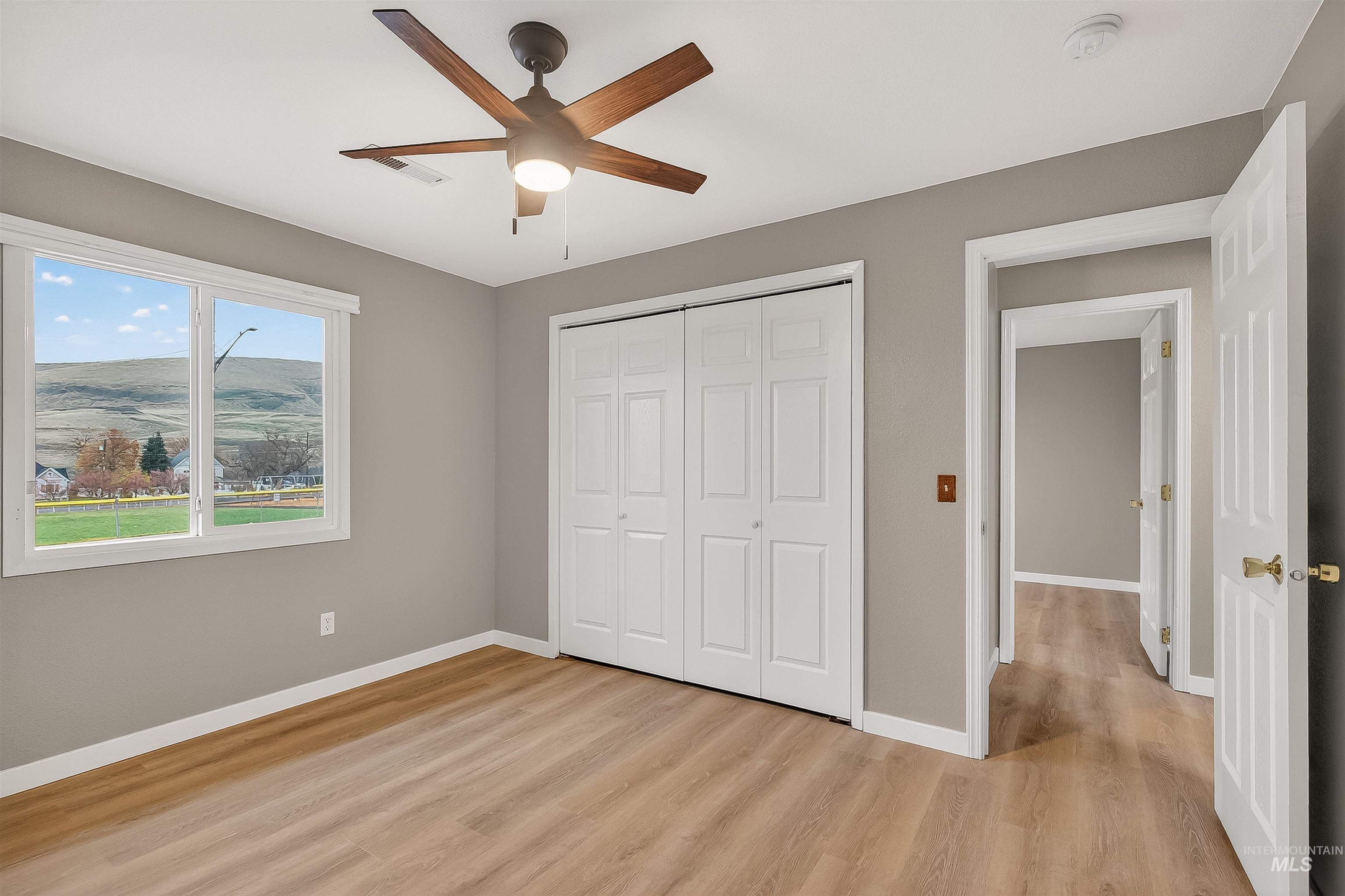 406 2nd Street Asotin, WA 99402 - Photo 22 of 37 Unfurnished bedroom with light wood-style flooring, a ceiling fan, and a closet