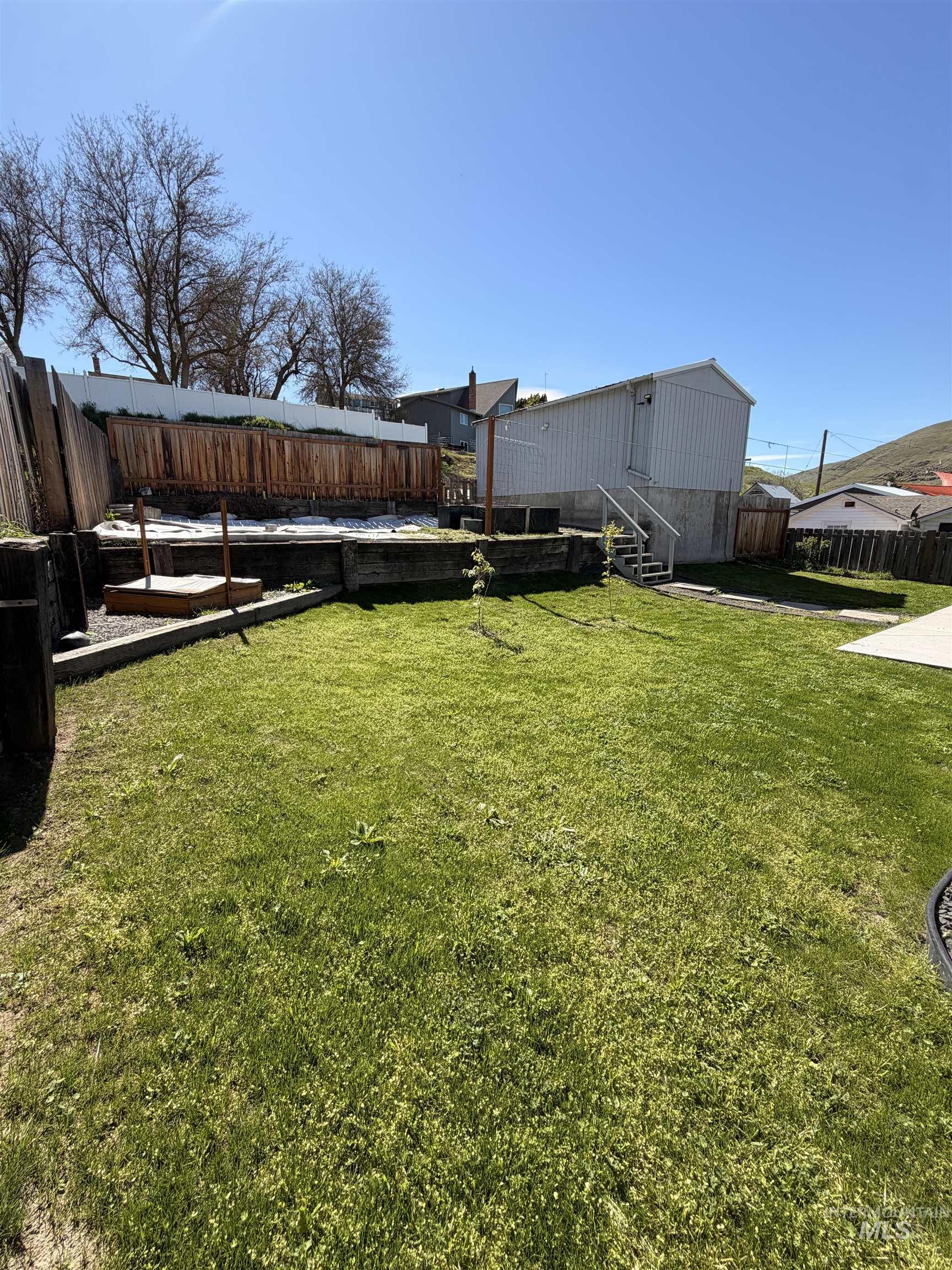 406 2nd Street Asotin, WA 99402 - Photo 24 of 25 Fenced backyard with a wooden deck and stairway