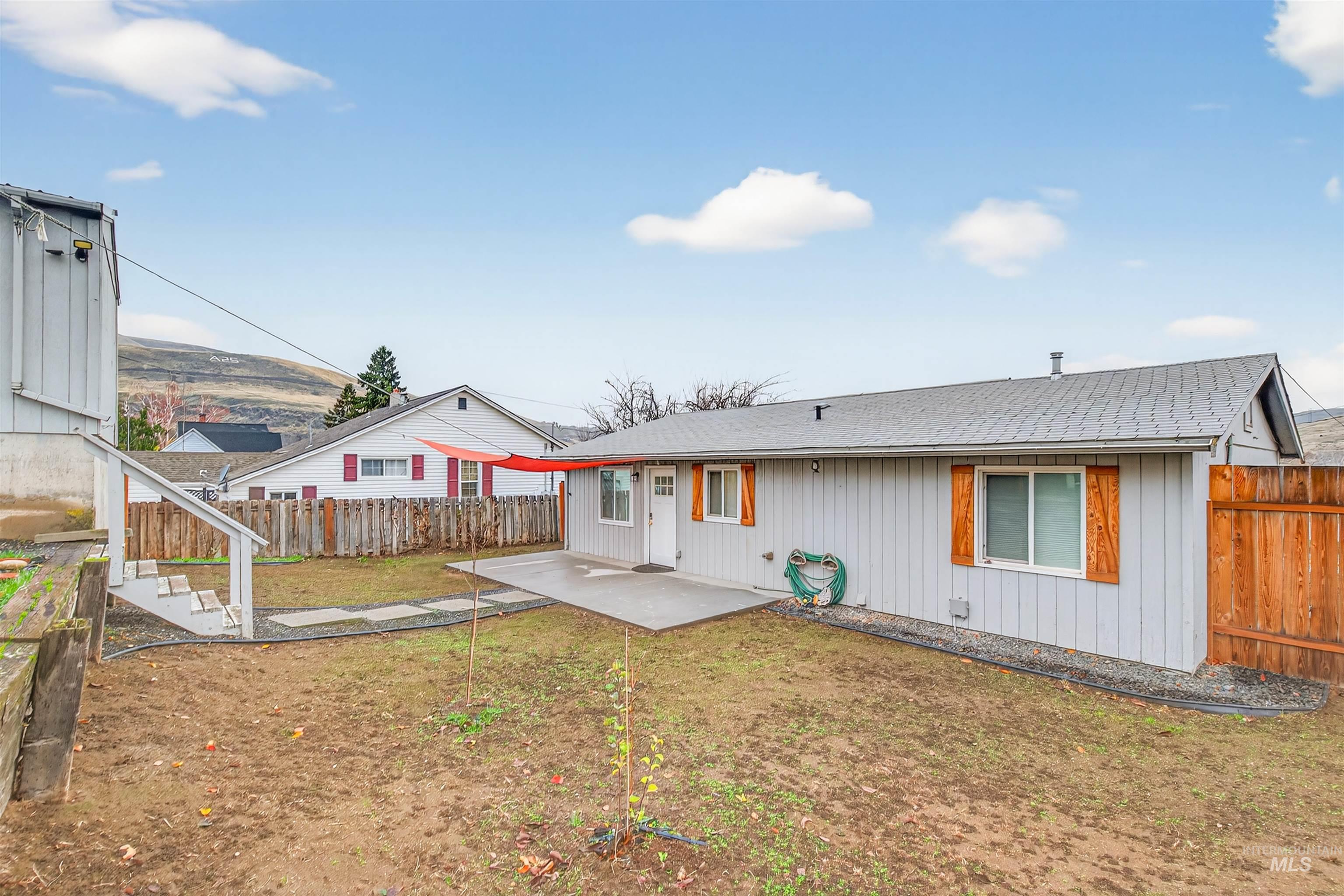 406 2nd Street Asotin, WA 99402 - Photo 24 of 37 Back of house featuring a patio, a fenced backyard, and a shingled roof