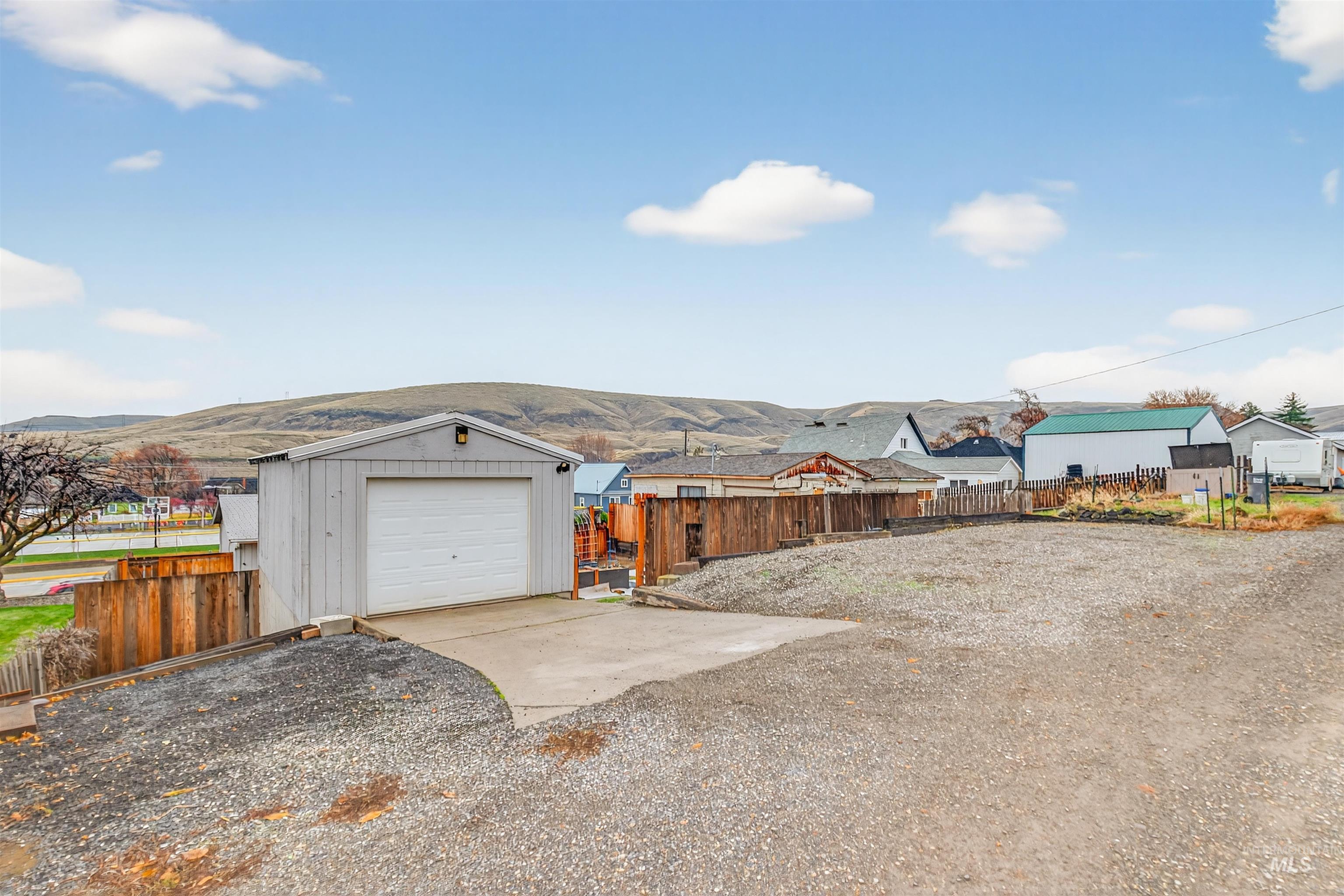 406 2nd Street Asotin, WA 99402 - Photo 32 of 37 View of yard with an outdoor structure, driveway, a garage, and a mountain view