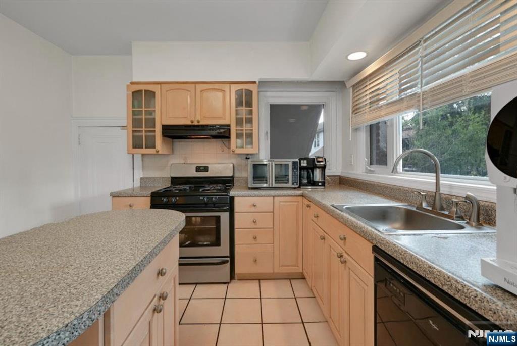 497 Oakdene Avenue Ridgefield, NJ 07657 - Photo 13 of 28 a kitchen with granite countertop a sink stove and cabinets