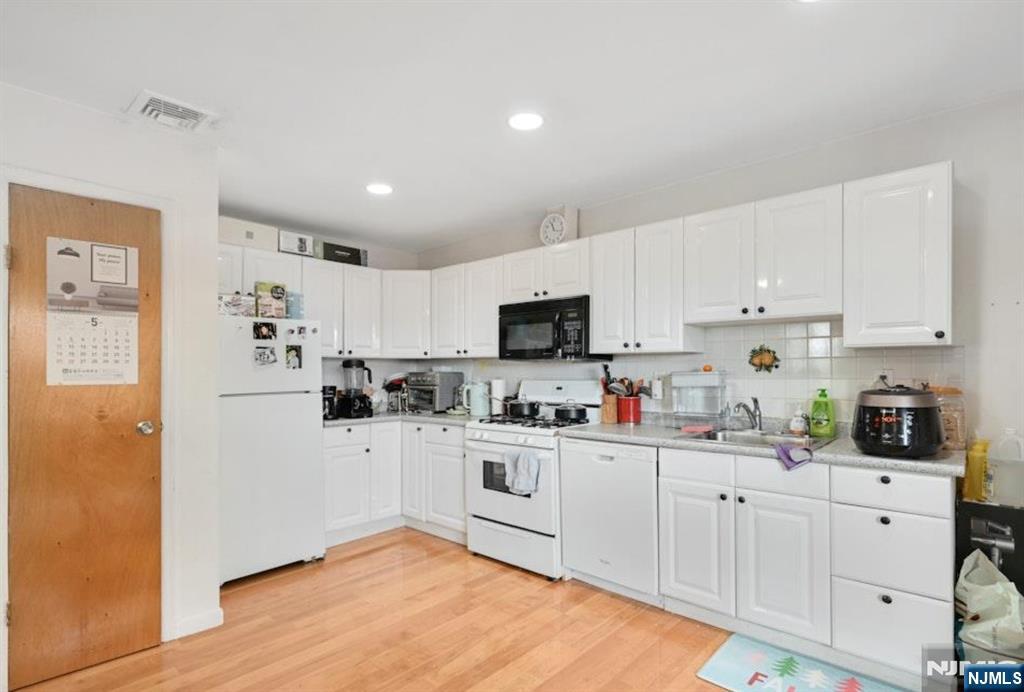 497 Oakdene Avenue Ridgefield, NJ 07657 - Photo 20 of 28 a kitchen with white cabinets and white appliances