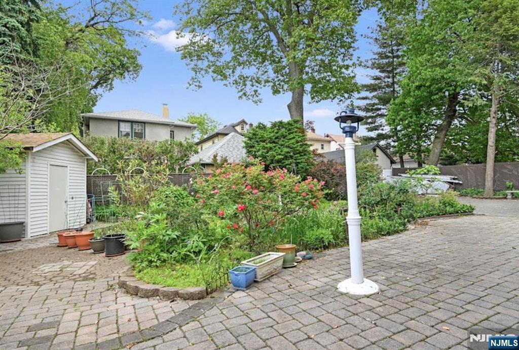 497 Oakdene Avenue Ridgefield, NJ 07657 - Photo 25 of 28 a view of a house with a bench in a garden