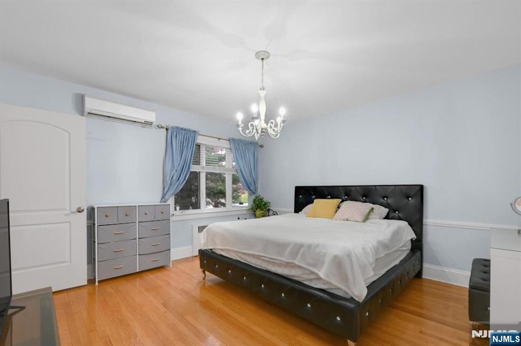 497 Oakdene Avenue Ridgefield, NJ 07657 - Photo 9 of 28 a bedroom with a bed chandelier and a dresser