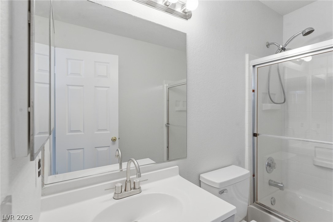5449 Bugle Way, Unit 104 Las Vegas, NV 89108 - Photo 18 of 33 This bright bathroom features a vanity with a sink, a toilet, and a shower-tub combination.