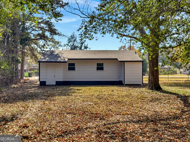 a house is sitting in middle of the forest