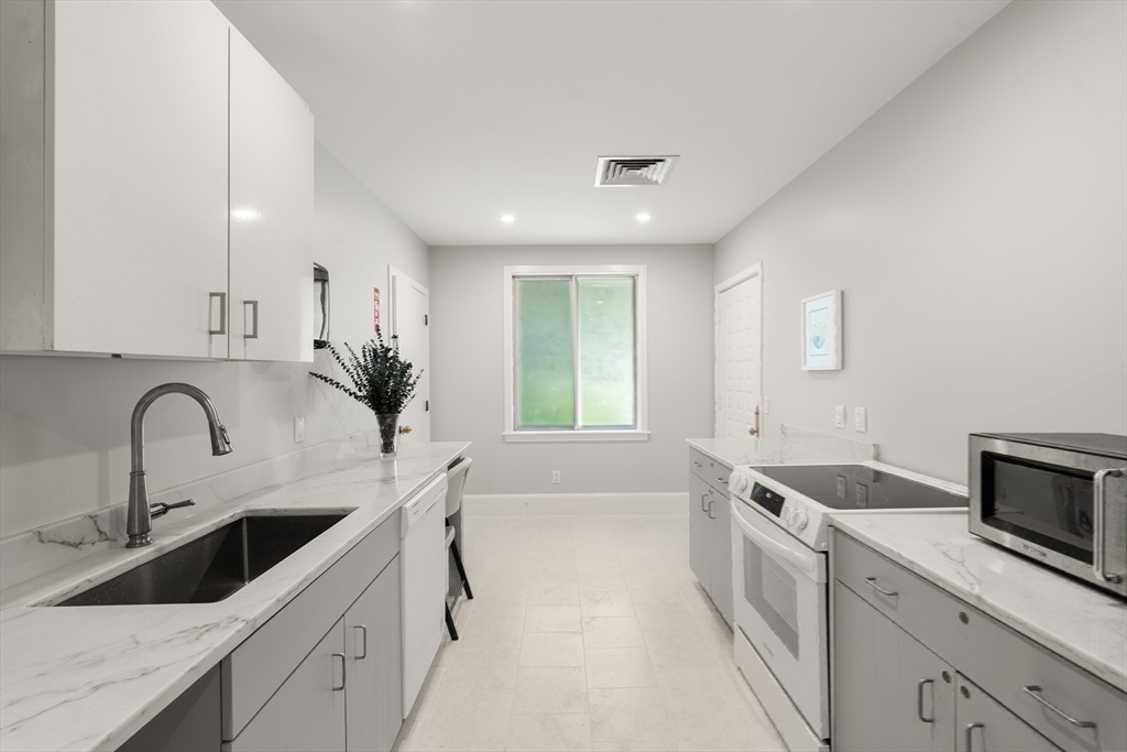 214 Allandale Road, Unit B Boston, MA 02467 - Photo 29 of 35 a kitchen with a sink cabinets and window