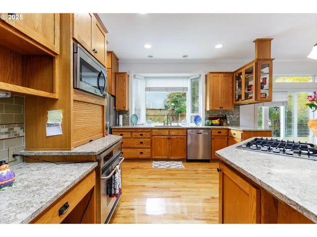 a kitchen with stainless steel appliances granite countertop sink stove and cabinets
