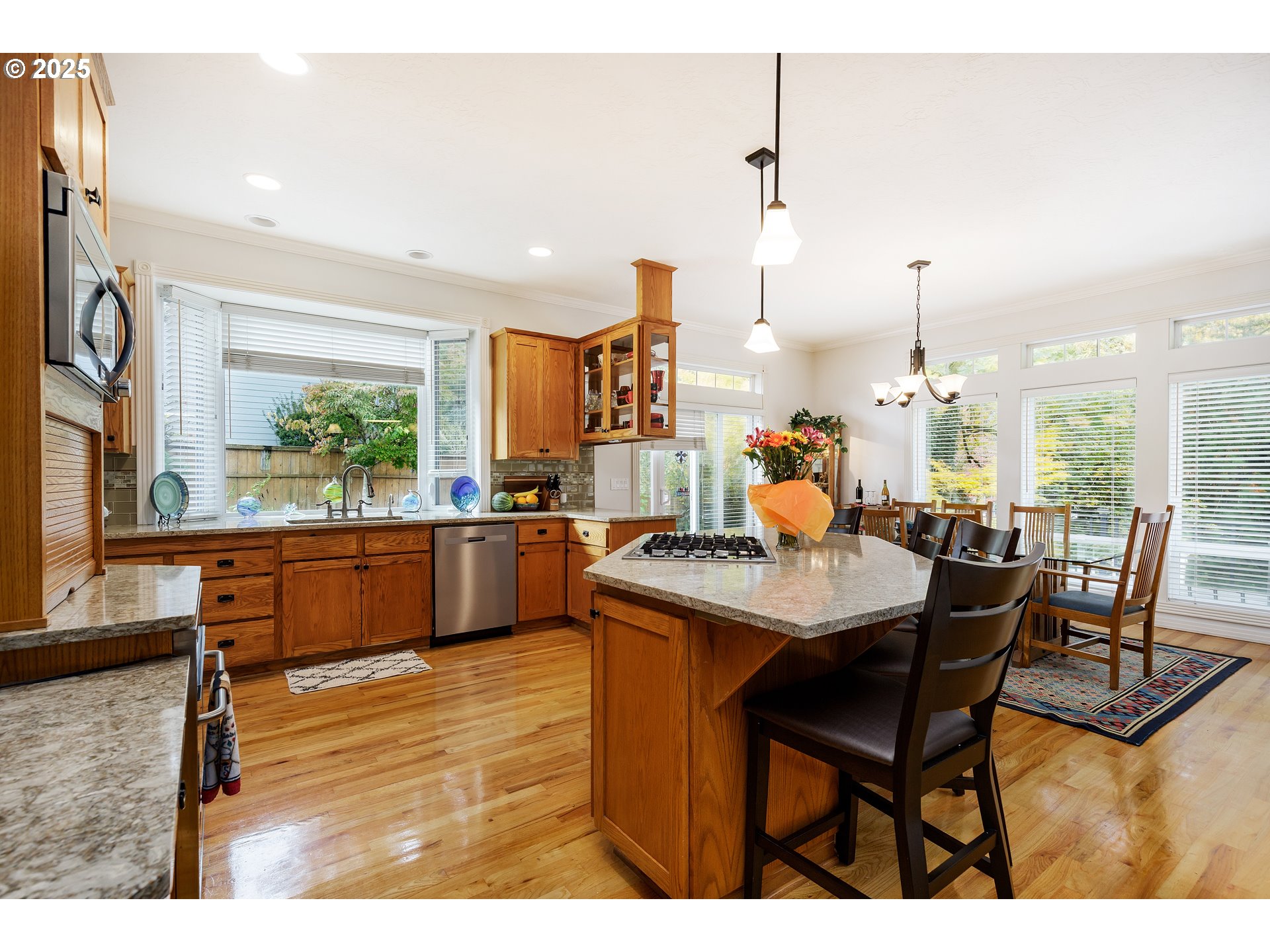 2573 Southeast Morlan Way Gresham, OR 97080 - Photo 15 of 47 a kitchen with stainless steel appliances kitchen island granite countertop a table chairs sink and wooden floor