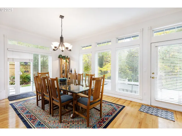 a view of a dining room and livingroom with furniture wooden floor a chandelier